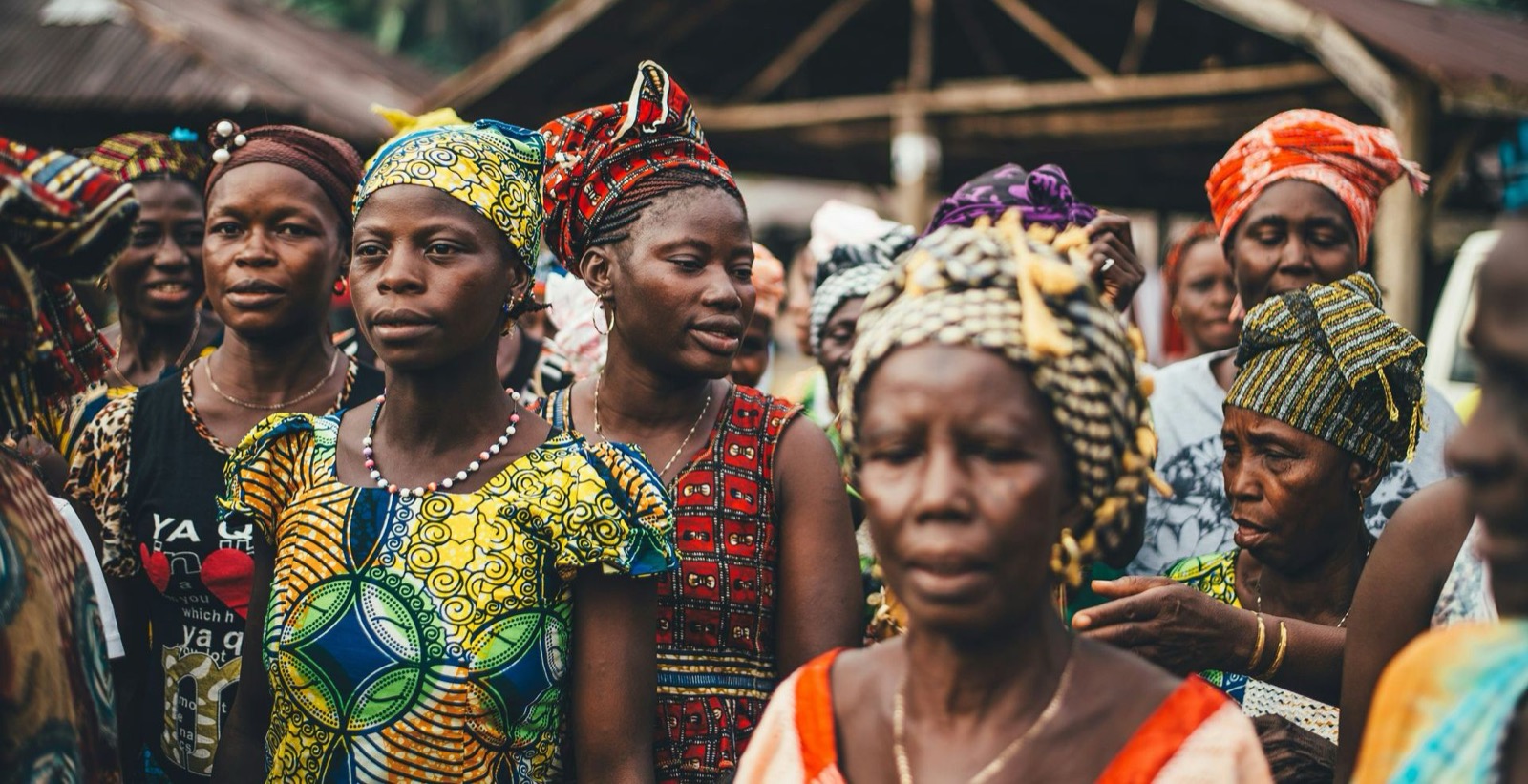 Femmes en pagnes colorés réunies sur un marché, contexte humanitaire en zone fragile