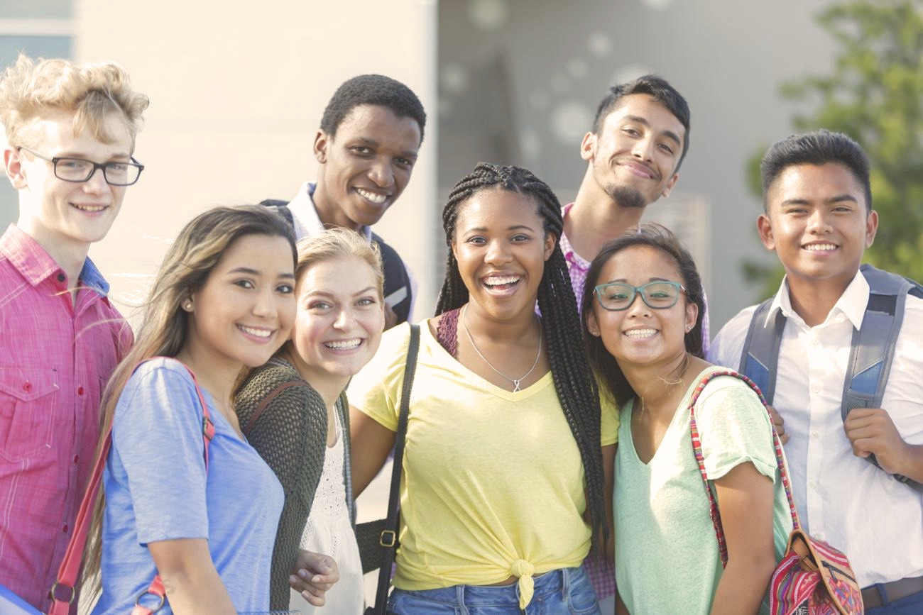 Groupe diversifié de jeunes adultes souriants en extérieur